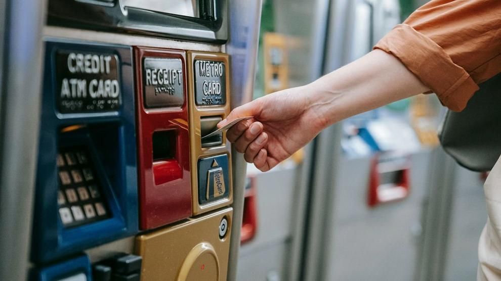 A commuter uses a metro ticket machine to pay for a subway card.