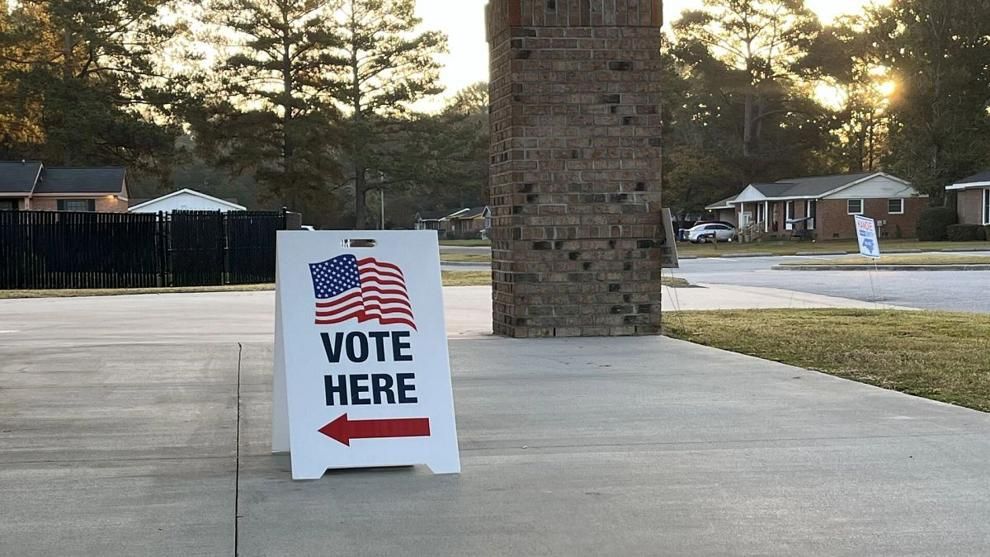 A sign directs voters to a polling location.