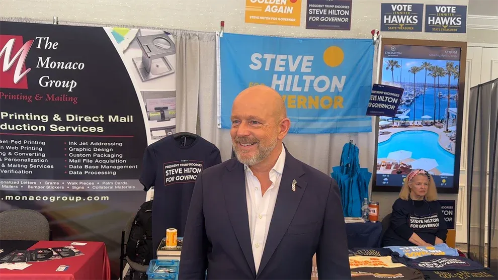 Steve Hilton, a former Fox host who's a leading Republican candidate for governor, stands by his campaign area at the California Republican Convention in San Diego, April 11, 2026. Photo: Madeline Shannon / The Center Square