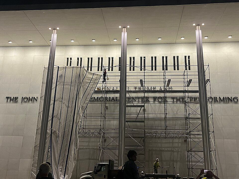 Workers placing a tarp around scaffolding, as they prepare to remove Donald Trump's name from the Kennedy Center