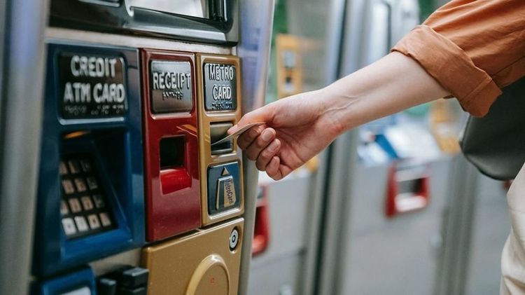 A commuter uses a metro ticket machine to pay for a subway card.