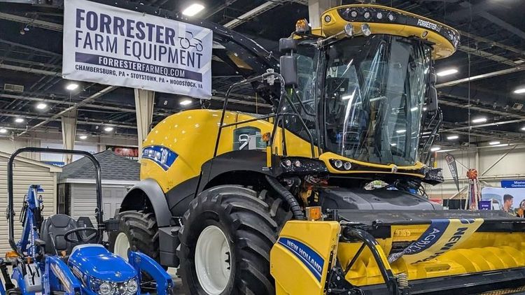 Tractors and farm equipment, including a large New Holland model, are displayed by Forrester Farm Equipment during the 2025 Pennsylvania Farm Show.