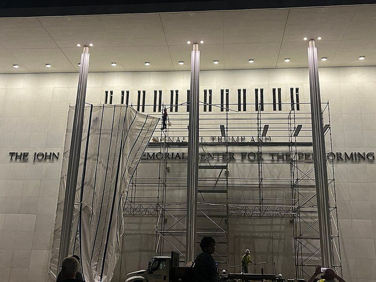 Workers placing a tarp around scaffolding, as they prepare to remove Donald Trump's name from the Kennedy Center