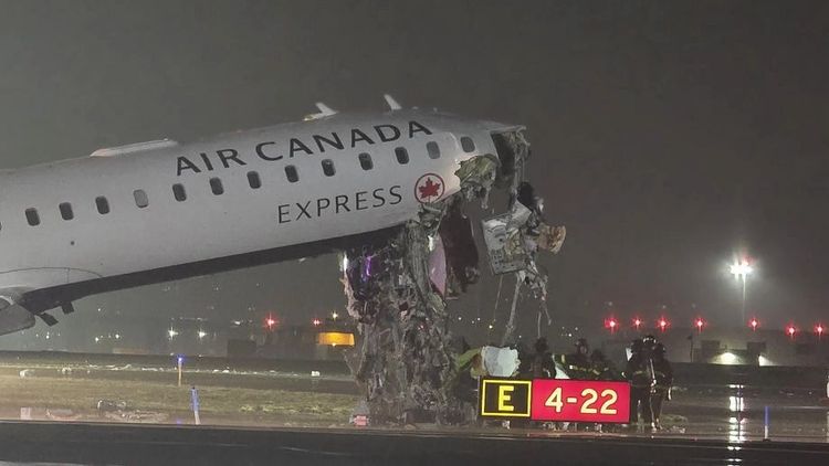 The Air Canada Bombardier CRJ-900 is seen with i's cockpit destroyed and nose in the air