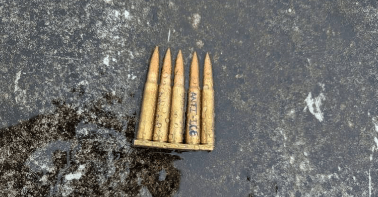 Rifle rounds in a "stripper clip" with "Anti-Ice" written on one round in marker