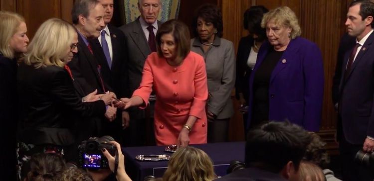 Nancy Pelosi signs the first Articles of Impeachment against President Trump.