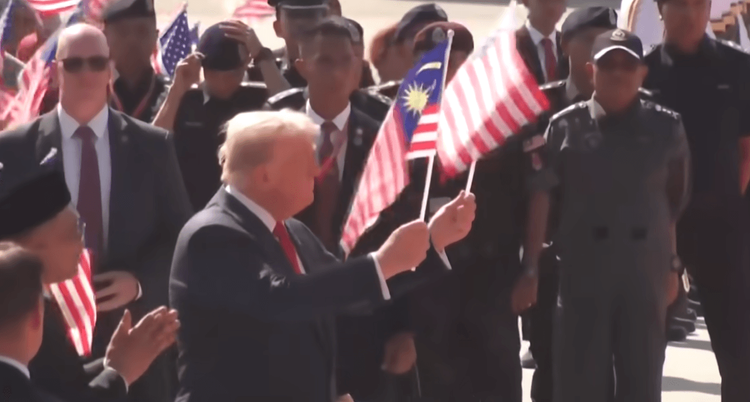 President Trump waving the US and Malaysian flags during his stop in Kuala Lumpur, Malaysia.