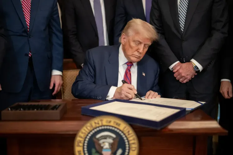 President Trump signs an Executive Order in the Oval Office.