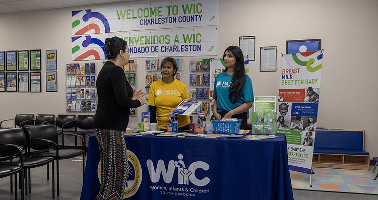 Community partners talk with a community member at an outreach event