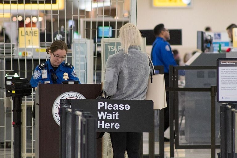 A Transportation Security Administration agent at a checkpoint verifying passenger identification, John Glenn Columbus International Airport